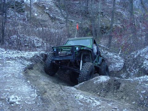 1992 Ford Bronco - Off-road SUV navigating a challenging muddy terrain during an outdoor excursion.