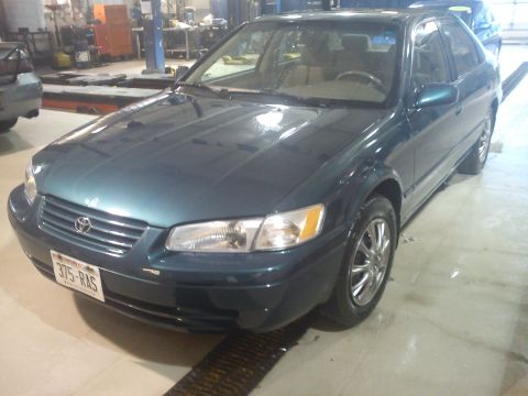 1998 Toyota Camry - This 1998 Toyota Camry sedan is shown from the front quarter angle in a workshop setting.
