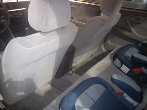 1998 Toyota Camry - The interior of a car is shown, with a focus on the back seats and child car seats.