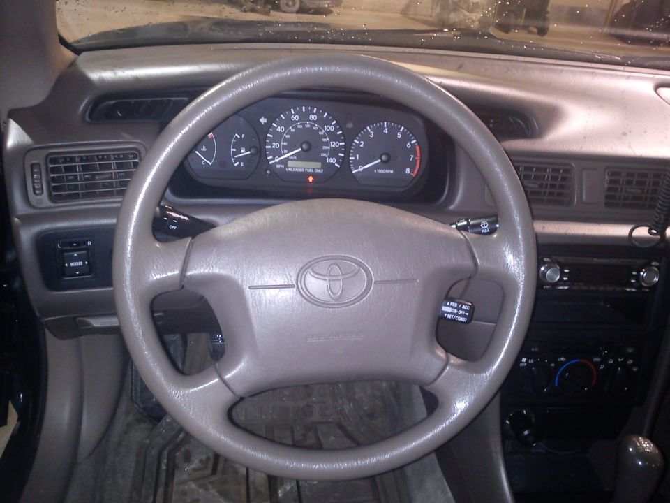 Tan dashboard and steering wheel with Toyota logo, showing instrument cluster and air vents