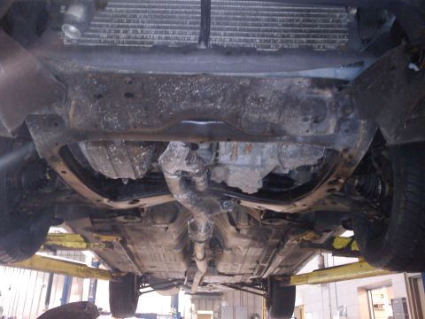 1998 Toyota Camry - The underside of a vehicle is visible, supported by a car lift in a workshop.