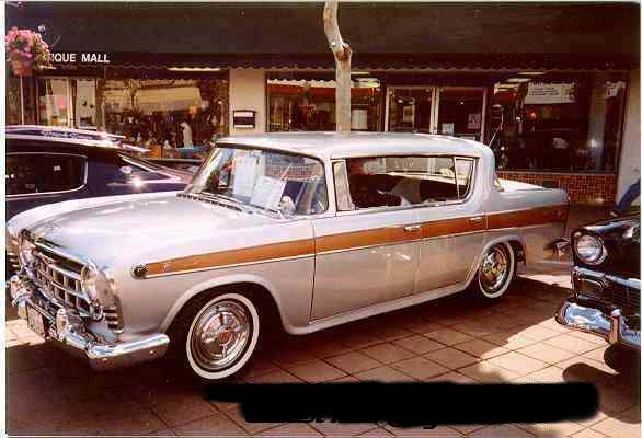 Silver sedan with wood trim on the side, parked in front of a store