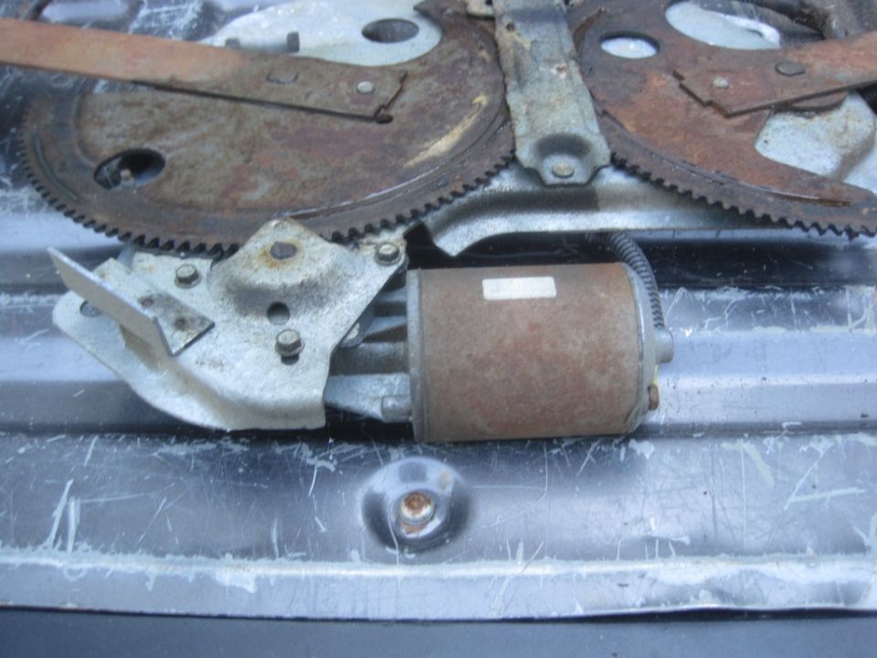 Rusty window regulator motor and gears with a metal bracket