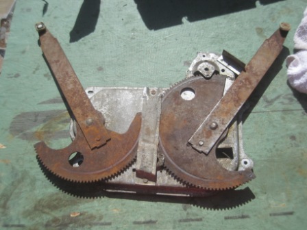 1993 Ford Bronco - This is a close-up of a rusty window regulator mechanism, likely for a vehicle door.