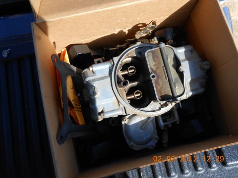 1986 Ford Bronco - A carburetor is shown inside a cardboard box, with a date stamp visible in the background.