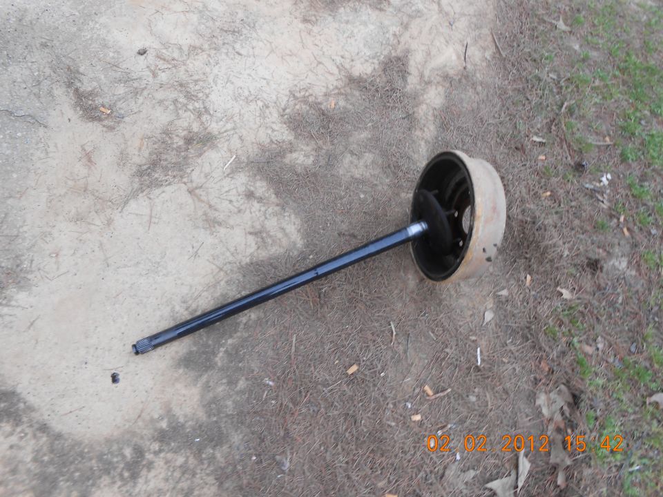 axle and brake drum assembly lying on the ground