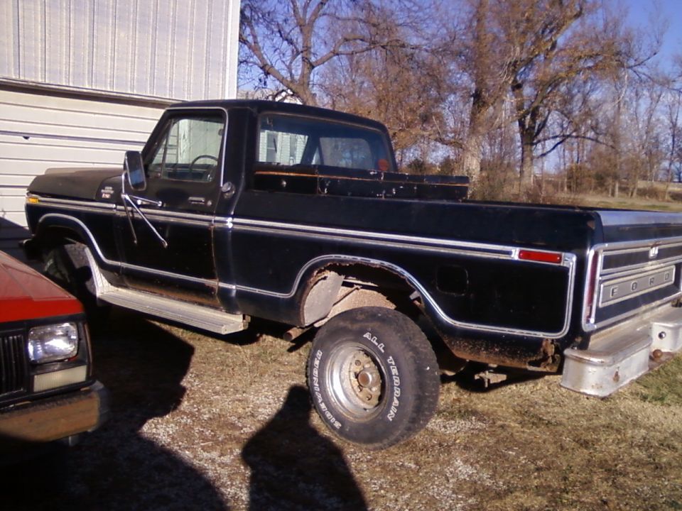1977 Ford F-150 pickup truck parked next to a red SUV