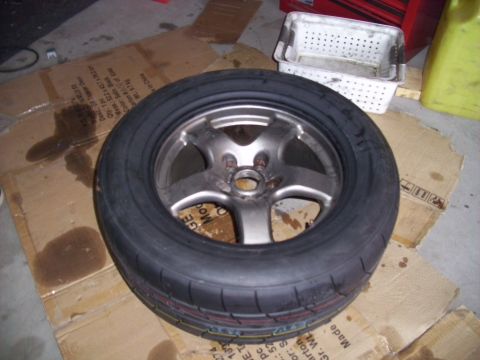 1995 Ford Probe - A tire and rim assembly rests on cardboard, with a Supermotors.net logo in the lower right corner.