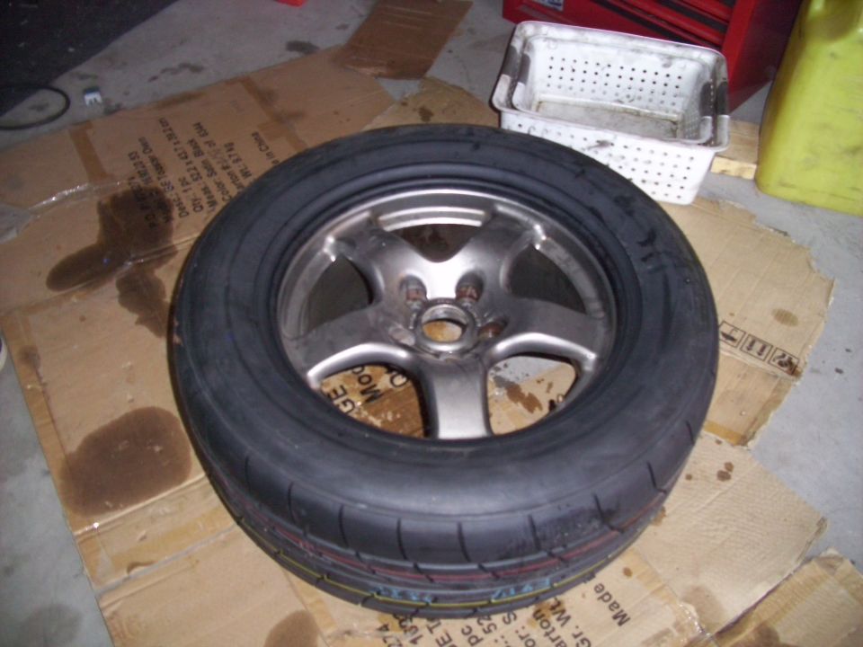 Tire and rim on cardboard. Supermotors.net logo visible