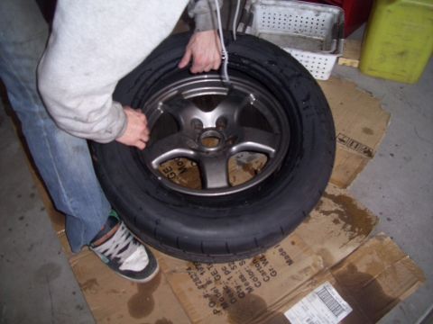 1995 Ford Probe - Tire and wheel assembly being worked on, resting on cardboard.