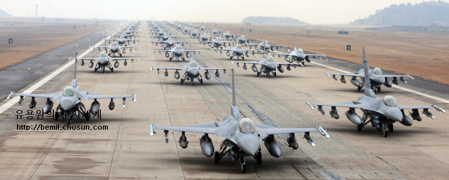 Many fighter jets lined up on a runway