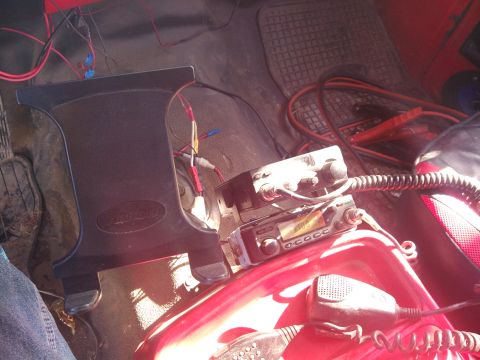 1979 Ford Bronco - Interior shot showing two CB radios and exposed wiring, with jumper cables visible on the floor.
