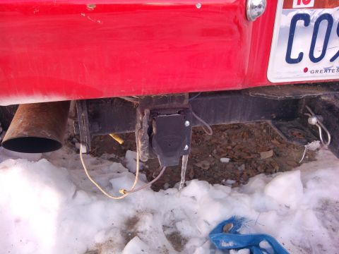 1979 Ford Bronco - Close-up view of the rear bumper and trailer hitch assembly of a red vehicle.