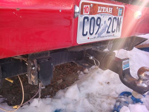 1979 Ford Bronco - Rear view of a red vehicle showing a trailer hitch and a Utah license plate.