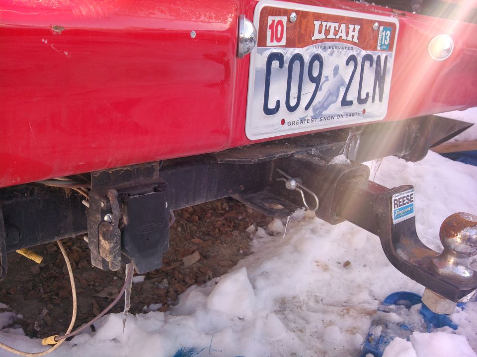 Red vehicle rear with trailer hitch and Utah license plate C09-2CN