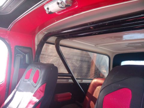 1979 Ford Bronco - Interior view of a vehicle showing red trim, a roll cage, and racing seats, with a visible watermark.