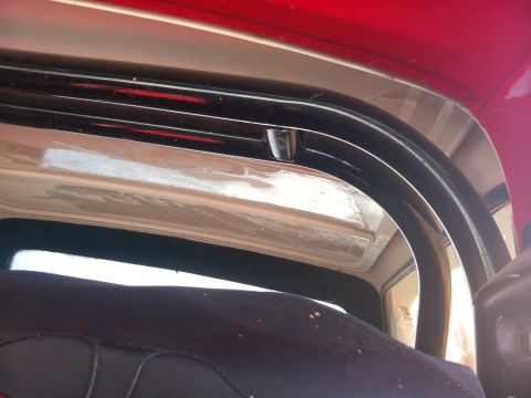 1979 Ford Bronco - Close-up view of the interior roll bar and red exterior paint on a 1979 Ford Bronco.