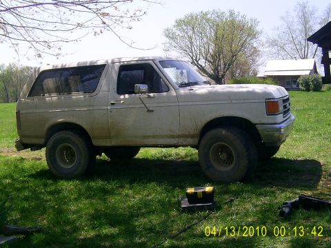 1990 Ford Bronco - This 1990 Ford Bronco is parked outside on a sunny day with a toolbox nearby.