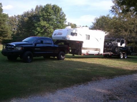 1967 Ford Mustang - A black Dodge Ram pickup truck is shown towing a fifth-wheel camper and a trailer with an off-road vehicle.