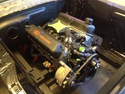 1965 Ford Mustang - Ford V8 engine with Ford Racing valve covers, installed in a vehicle's engine bay.
