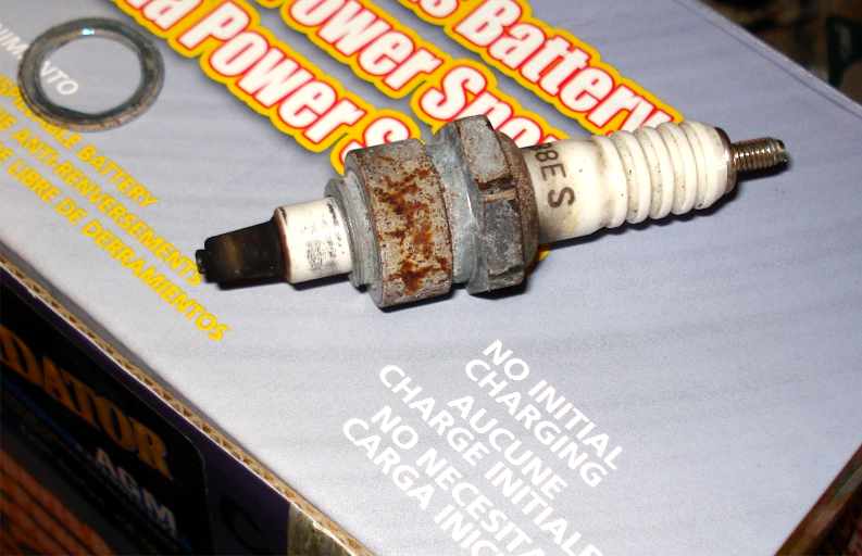 Used spark plug on box with text 'Power Spark Battery'