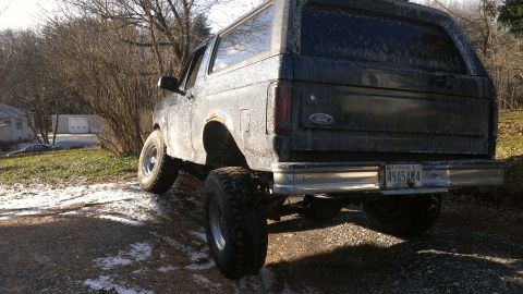 1995 Ford Bronco - This Ford Bronco is parked on a dirt road with a slightly lifted suspension and large off-road tires.