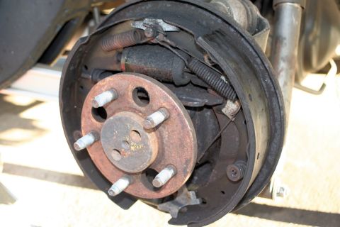 1976 Ford Ranchero - Close-up view of a worn rear drum brake assembly, showing brake shoes and springs.