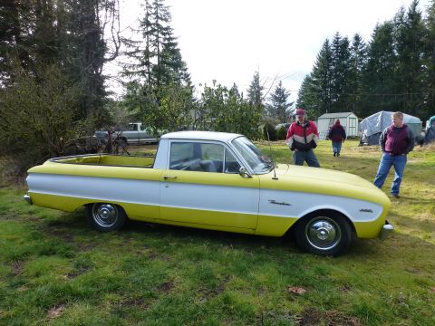 1961 Ford Ranchero - 1961 Ford Ranchero pickup truck in yellow and white, with people standing around it outdoors.