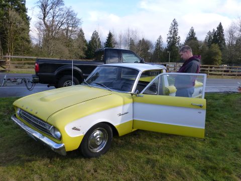 1961 Ford Ranchero - A two-tone Ford Falcon is parked on a grassy area beside a black pickup truck.