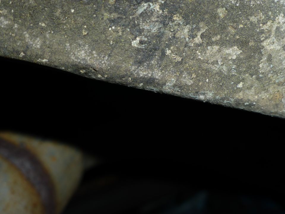 Rusted metal pipe with textured surface against black background