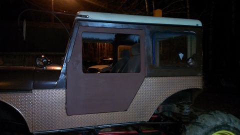 1978 Ford Bronco - This customized SUV features diamond plate fenders and a two-tone roof, with a glimpse of the interior visible through the windows.