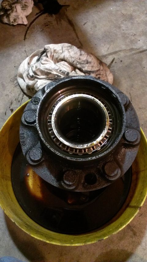 1995 Ford Bronco - Wheel hub assembly soaking in oil, likely for cleaning or maintenance.