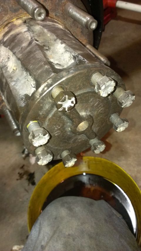 1995 Ford Bronco - Close-up of a vehicle's wheel hub assembly, with a yellow oil drain pan visible below.