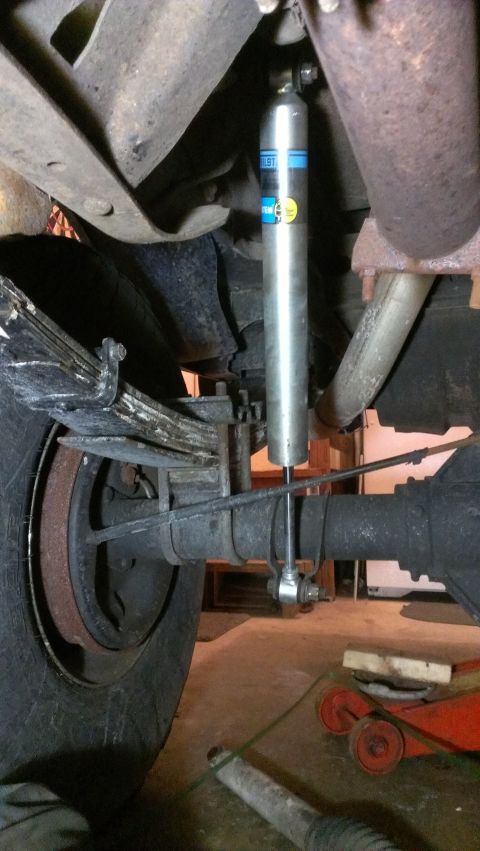 1995 Ford Bronco - Close-up of a rear suspension system a Bilstein shock absorber attached to the axle and leaf spring assembly.