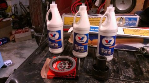 1995 Ford Bronco - Three bottles of Valvoline 80W-90 gear oil and automotive parts are laid out on a dark, textured surface.