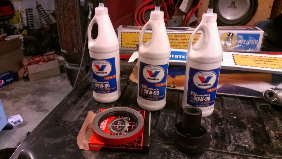Three bottles of Valvoline 80W-90 gear oil, a red-ringed seal, and a black part sit on a dark surface