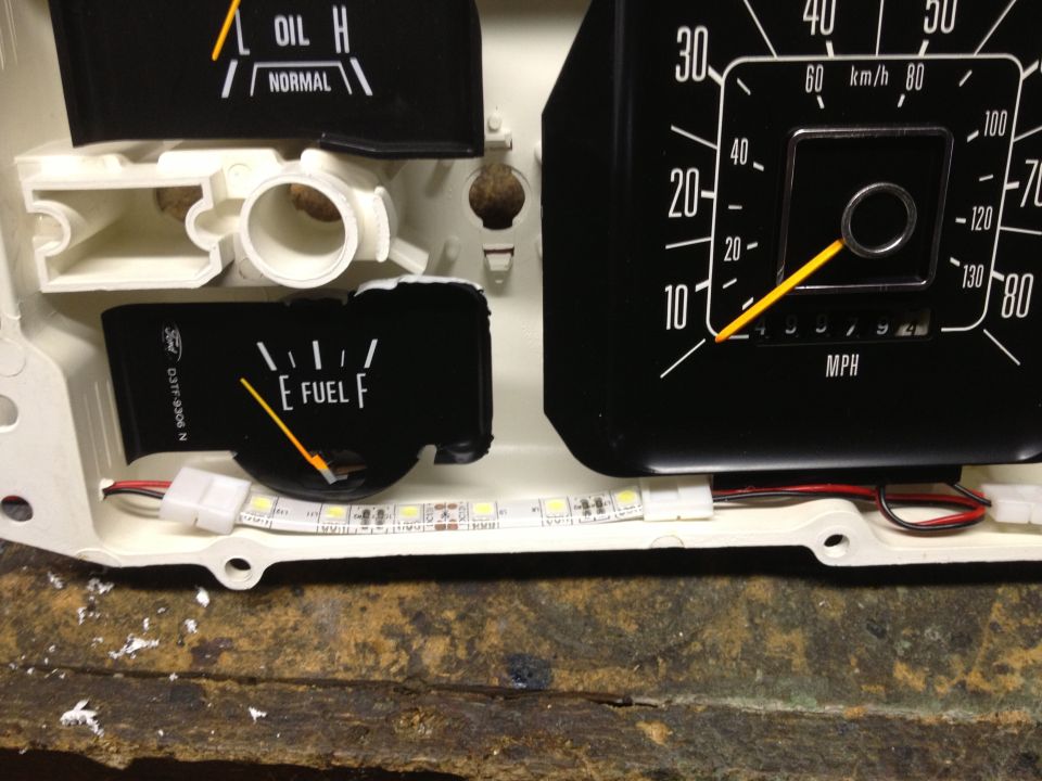 Vehicle dashboard gauges showing oil level, fuel level, and speedometer