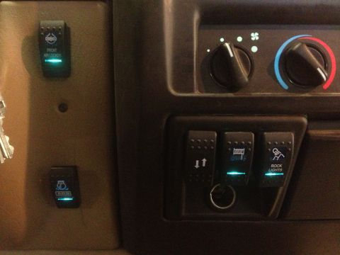 2000 Jeep TJ - Interior view of a vehicle's dashboard, showing various illuminated auxiliary switches.
