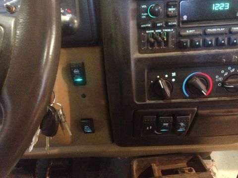 2000 Jeep Wrangler - Interior view of a 2000 Jeep TJ dashboard, showing auxiliary switches and radio.
