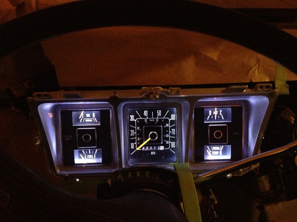 Dashboard gauges with illuminated needles and indicators, including fuel and temperature gauges. A "P R N D" selector is visible