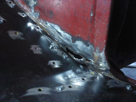 1978 Ford Bronco - Metal repair work on a vehicle's floor pan, showing rust damage and new fasteners.