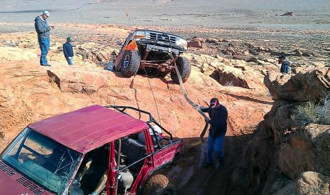 1994 Ford Bronco - Two off-road vehicles are stuck in a desert landscape, with people attempting to free one.