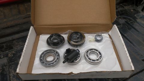 1995 Ford Bronco - Several wheel bearings and a hub assembly part are laid out in a cardboard box.
