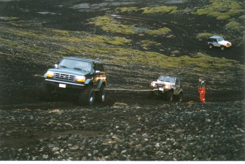 1996 Ford Bronco - A 1996 Ford Bronco tows another vehicle through a challenging off-road terrain.