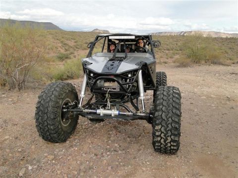 1967 Ford Mustang - Custom off-road buggy with two occupants navigates a desert trail under a cloudy sky.