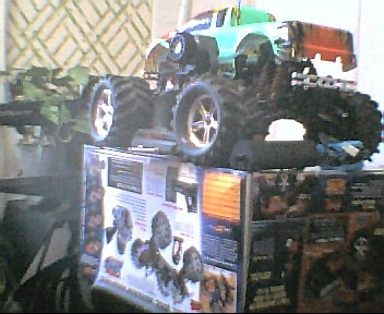 1980 Ford Bronco - A toy monster truck is displayed on top of a box, with another toy vehicle partially visible behind it.