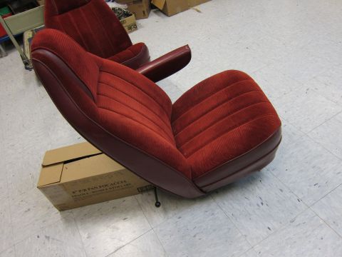 1991 Ford LTD Crown Victoria - Two car seats are shown indoors, resting on a box. The seats are upholstered in red velour with burgundy vinyl accents.