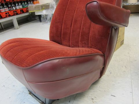 1991 Ford LTD Crown Victoria - Close-up of a red velour seat with burgundy vinyl trim and an armrest, likely from an older vehicle.