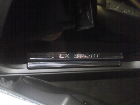 2003 Ford Crown Victoria - Close-up of a chrome LX SPORT door sill plate inside a vehicle.