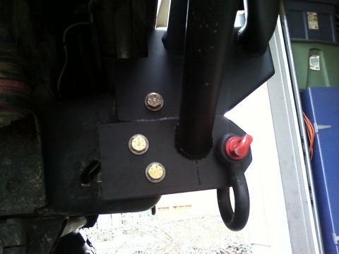 1989 Ford Bronco - Close-up of a custom winch bumper attachment, a red shackle mount and heavy-duty bolts.